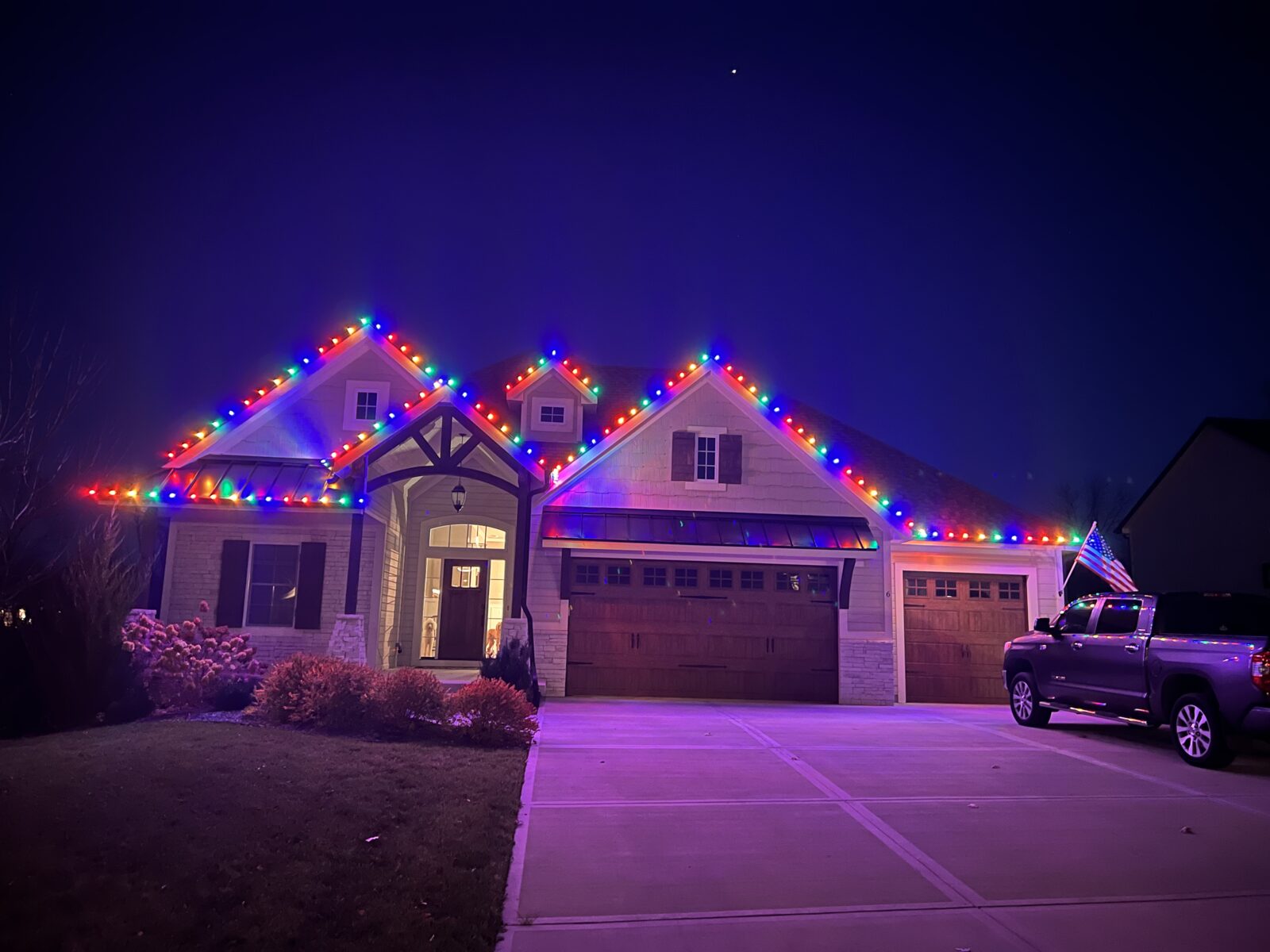 Multicolor red, green, and blue C9 LED lights on large craftsman home in Kansas City