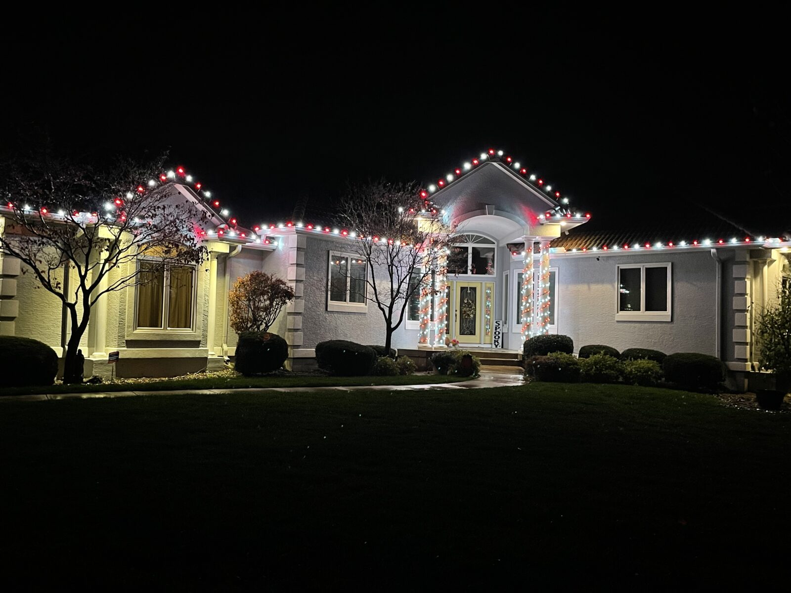Red and white C9 lights on luxury ranch with light curtain on doorway